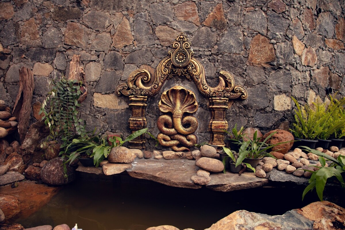 Gold-colored icon of naga at pond