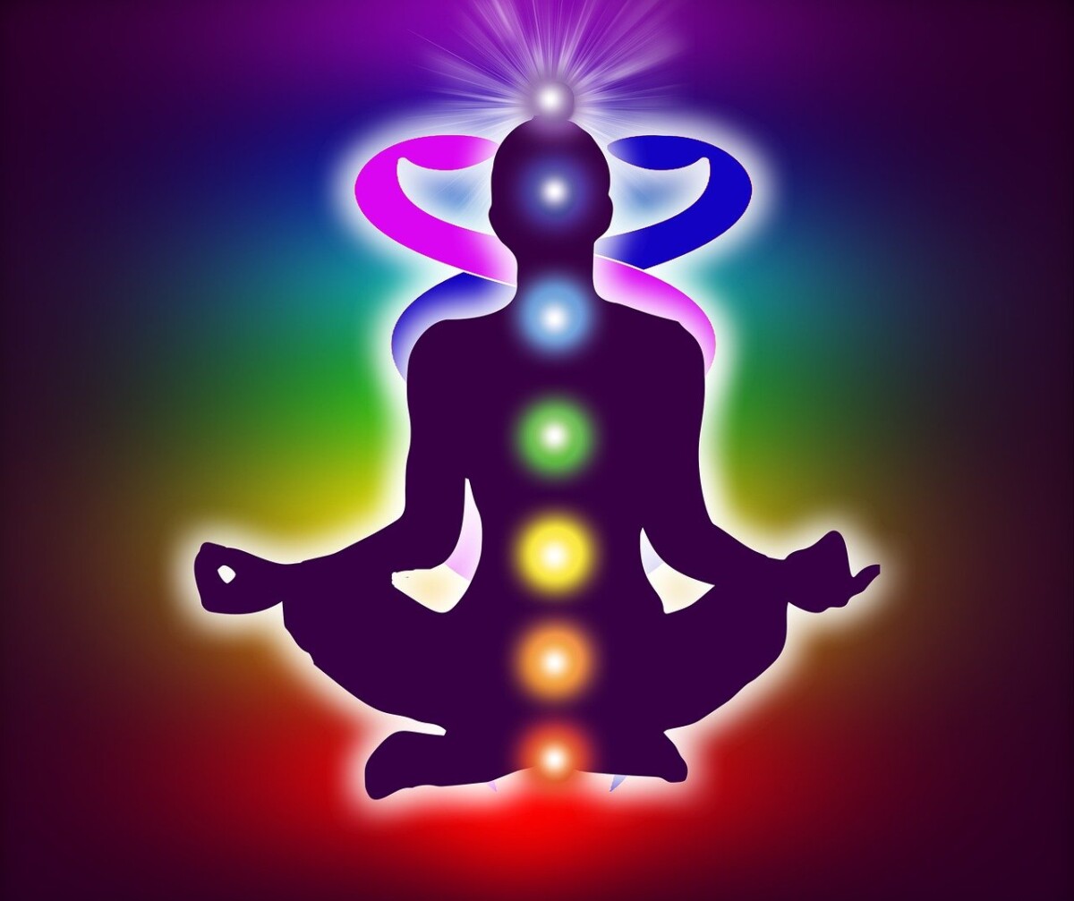 A meditative figure sits in a lotus position, vibrant with the chakras, or psychic centers of spiritual realization.