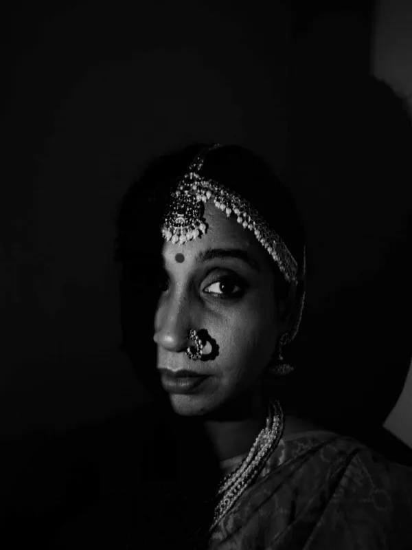 Black and white photo of a Hindu woman wearing traditional South Indian jewellery.