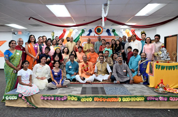 Sacramento Hindus pose on a podium along with a visiting religious teacher from India.