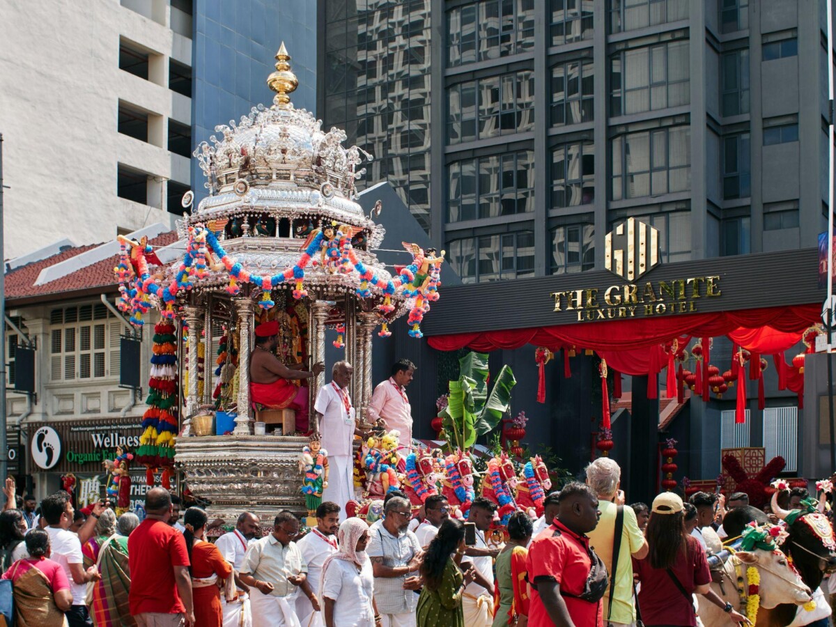 A bustling Thaipusam procession winds through the streets of Malaysia, anchored by the ornate silver chariot carrying Murugan, the “icon of war.”