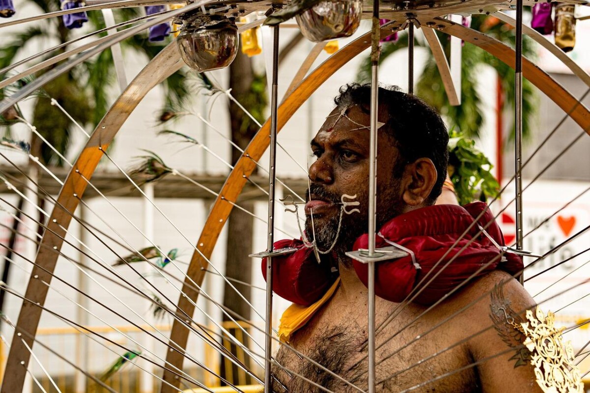 A Thaipusam observer bears the burden of his kavadi, demonstrating strength, commitment, and unwavering devotion.