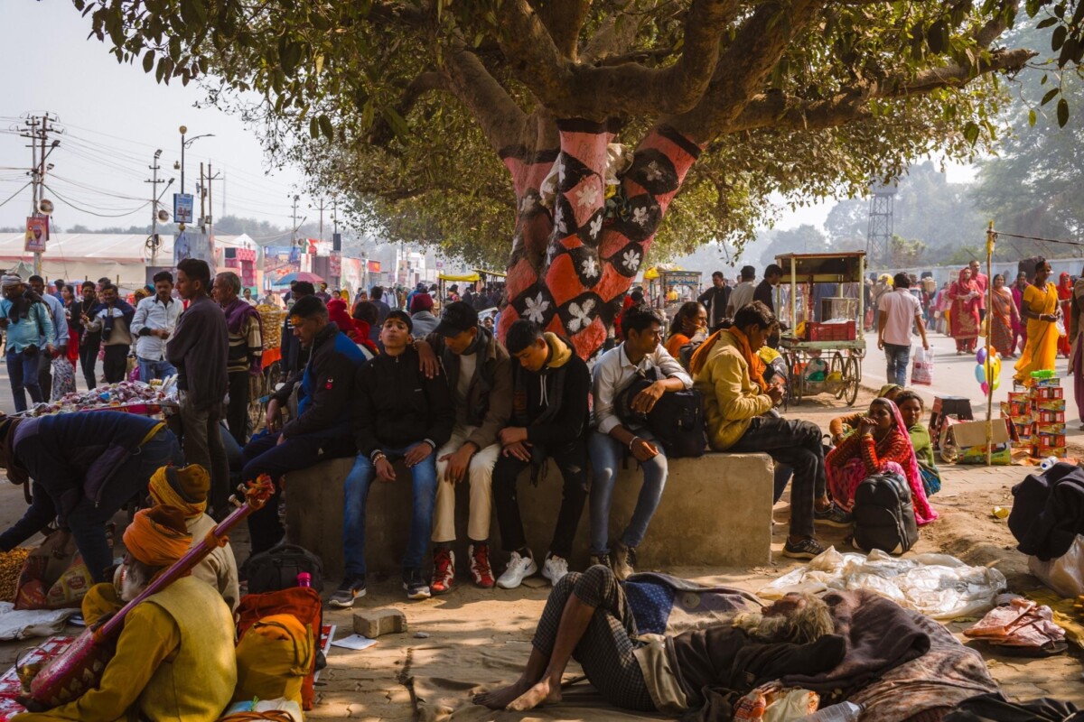 Pilgrims resting under a tree at the 2025 Kumbh Mela, Prayagraj, India