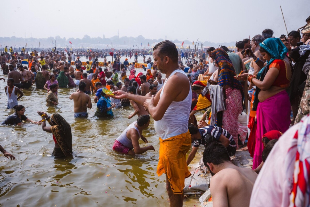 A man prays while standing in the water at the 2025 Kumbh Mela, Prayagraj, India